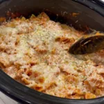 A delicious serving of creamy Italian chicken pasta made in a crockpot, topped with melted mozzarella cheese and fresh parsley