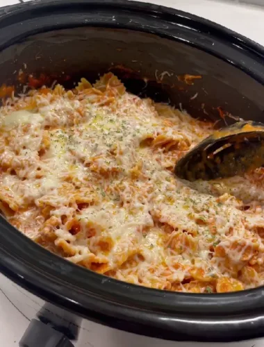 A delicious serving of creamy Italian chicken pasta made in a crockpot, topped with melted mozzarella cheese and fresh parsley