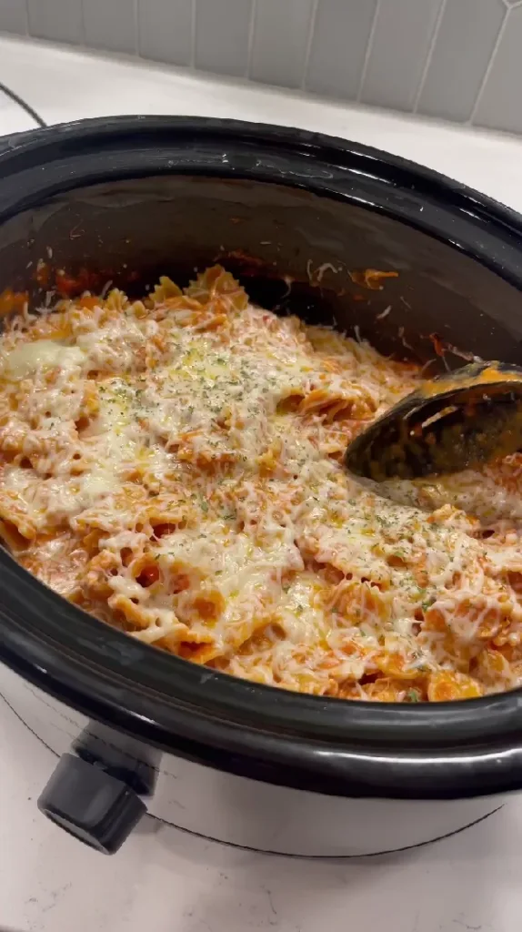 A delicious serving of creamy Italian chicken pasta made in a crockpot, topped with melted mozzarella cheese and fresh parsley