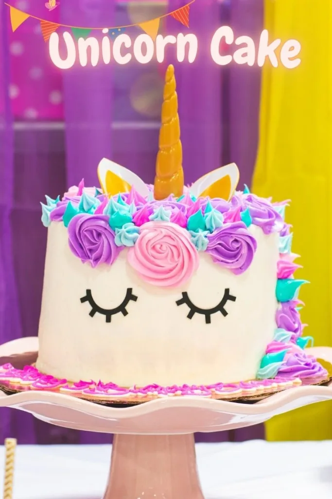 A beautifully decorated unicorn cake with pastel-colored frosting, a golden horn, and a mane of swirled buttercream rosettes in pink, purple, and blue.