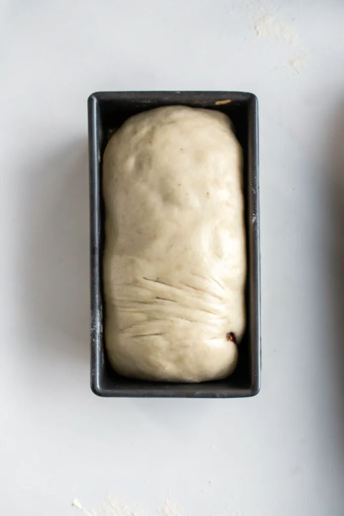 a loaf of Vegan Cinnamon Swirl Breada in a black pan